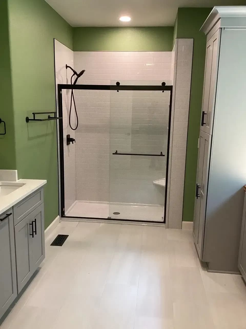 Long view of the floor and shower stall of Erik L.’s completed project