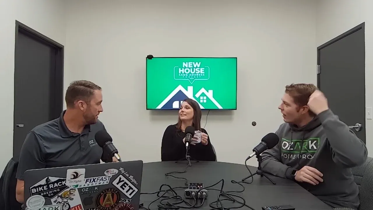 The Founder of Ozark Home Pros, Eric Barker, and his wife Charis, sitting with a manager at a black table discussing home improvement and remodeling topics for their ‘New House, Same Address’ podcast.