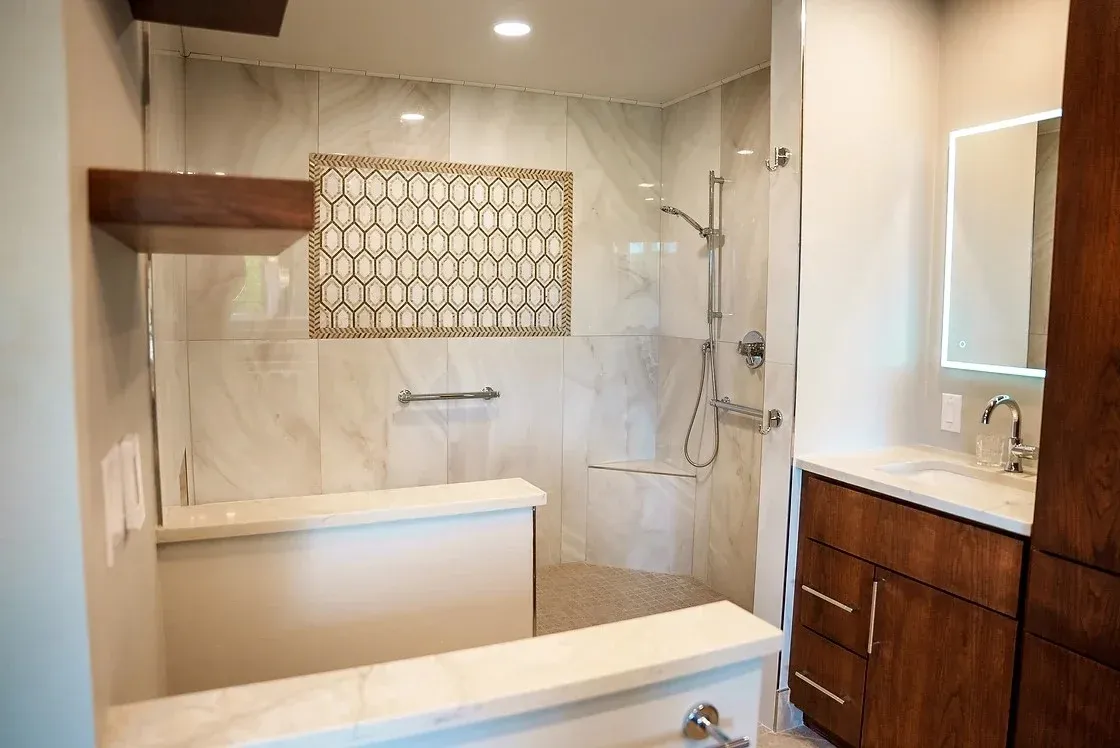A newly remodeled residential bathroom in Northwest Arkansas with a luxurious new walk-in shower and intricate tile surround.