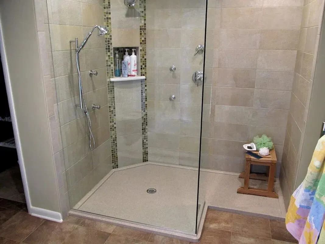 A new walk-in shower with a glass door, seating, and two different shower areas with new chrome hardware.