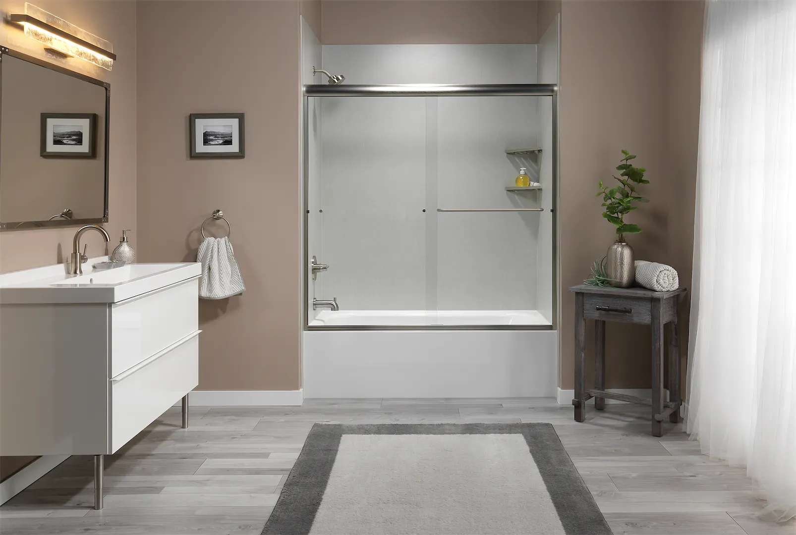 A converted tub-to-shower with sliding glass doors and a white basin.