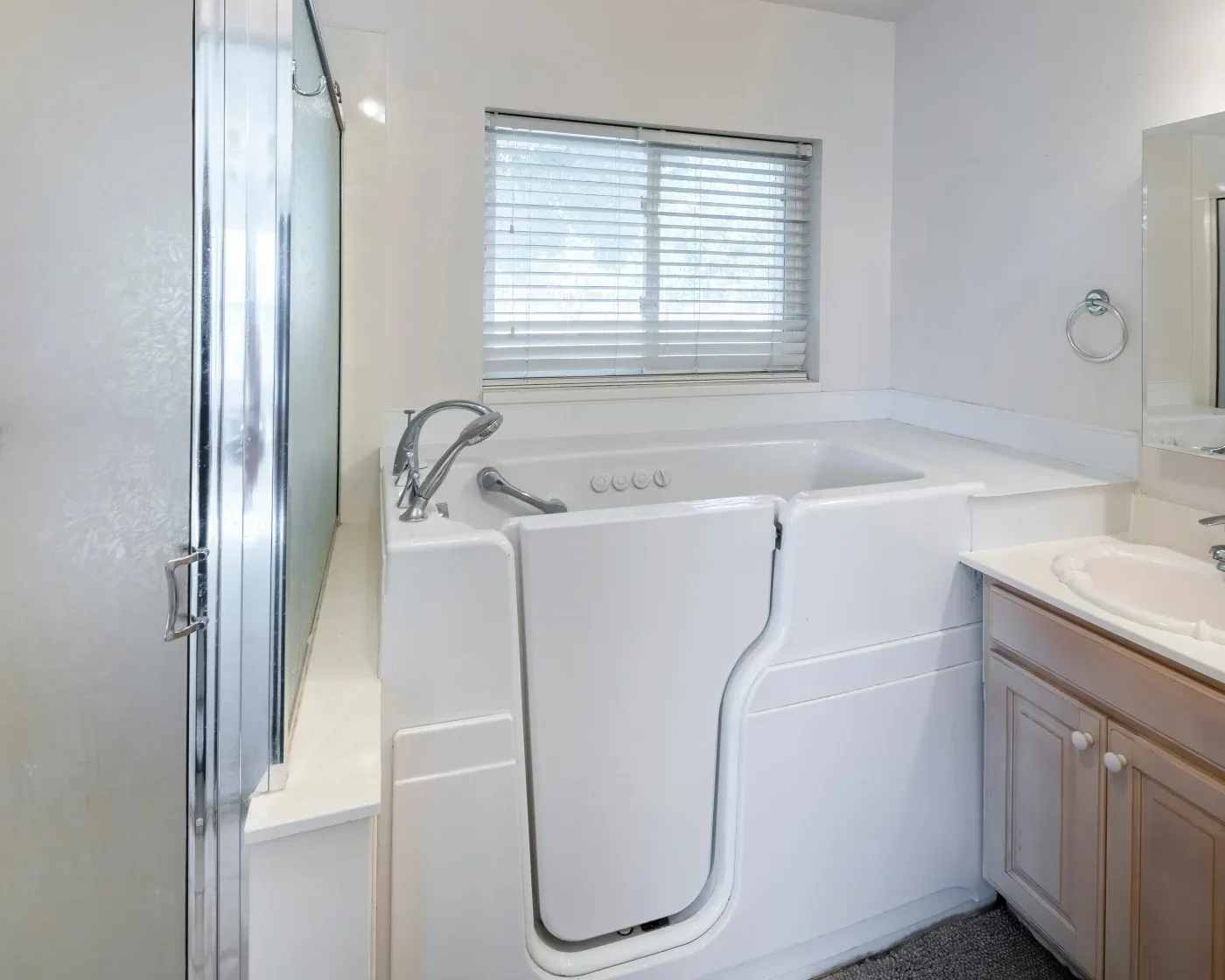White walk-in tub under window.